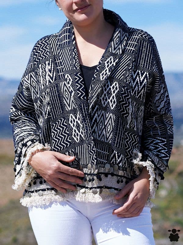 Chaqueta boho Nashville en blanco y negro con flecos y detalles de monedas en el bajo, vista de frente en exterior